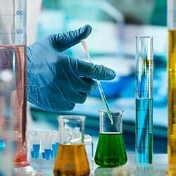 Scientist carefully mixing chemical solutions.