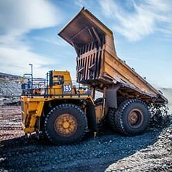 Extra large dump truck unloading rock and soil.