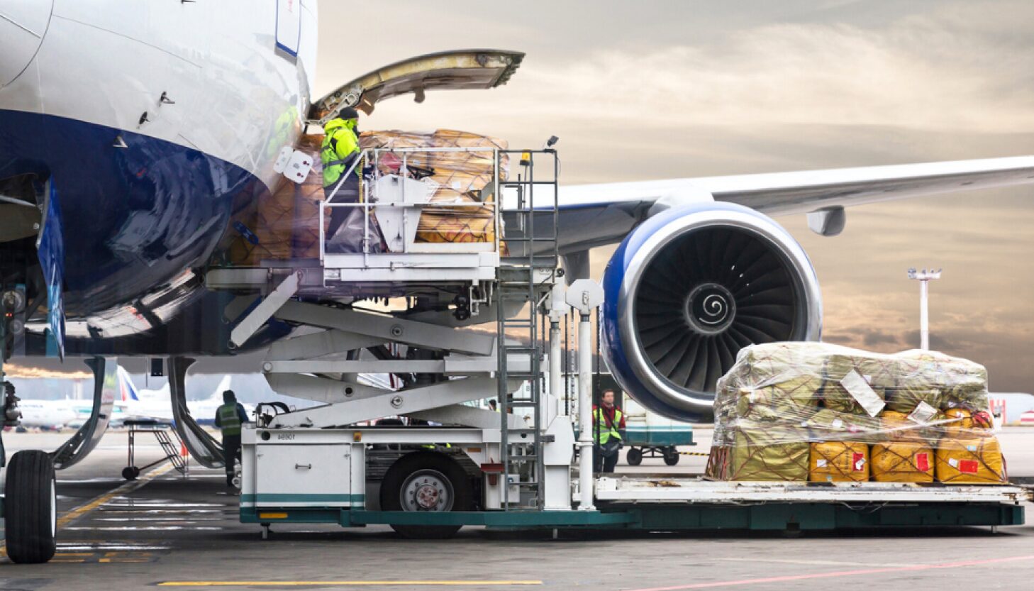 Ground crew loading general cargo onto a plane for international air freight shipping.