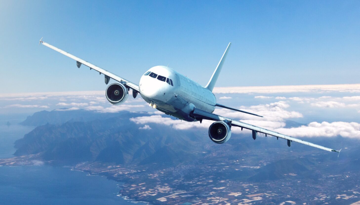 Commercial cargo charter aircraft flying above clouds during international shipment.